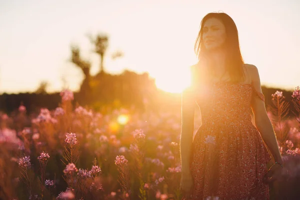 Girl on blooming Sally flower field at sunset. Lilac flowers and woman. — Stock Photo, Image