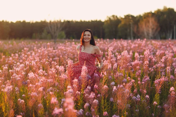 Girl on blooming Sally flower field at sunset. Lilac flowers and woman. — Stock Photo, Image