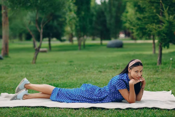 Bella giovane donna adulta in abito blu picnic a prato nel parco — Foto Stock