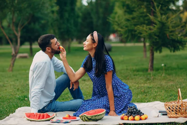 Mladý dospělý žena a muž pár piknik na zelené trávě louka v parku — Stock fotografie