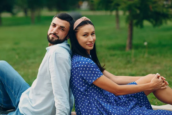 Jovem mulher adulta e homem casal piquenique no prado de grama verde no parque — Fotografia de Stock