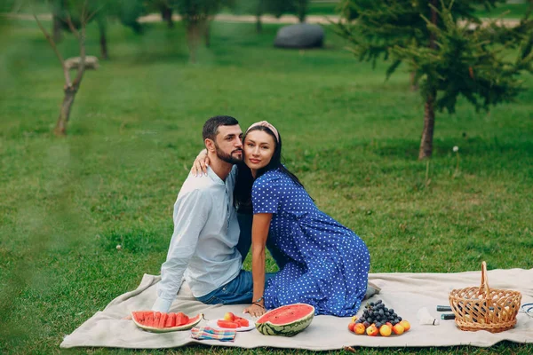 Молодая взрослая женщина и мужчина пара пикник на зеленом лугу травы в парке. — стоковое фото