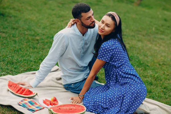 Giovane donna adulta e uomo coppia picnic a prato erba verde nel parco con frutta e cesto. — Foto Stock