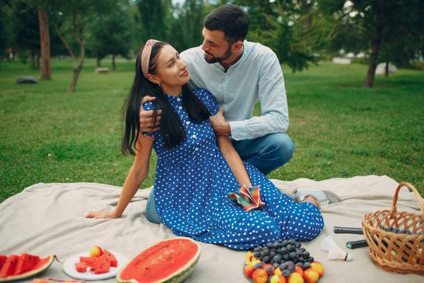 Jovem mulher adulta e homem casal piquenique no prado de grama verde no parque com frutas e cesta. — Fotografia de Stock