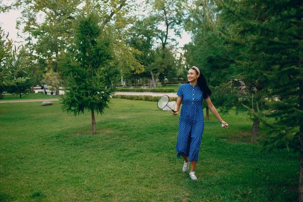 Giovane donna adulta che gioca a badminton nel parco — Foto Stock