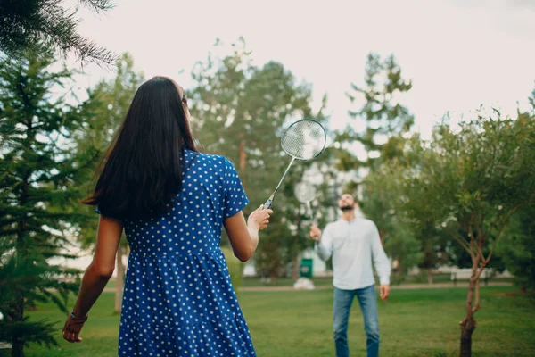 Jeune couple adulte jouant au badminton dans le parc — Photo