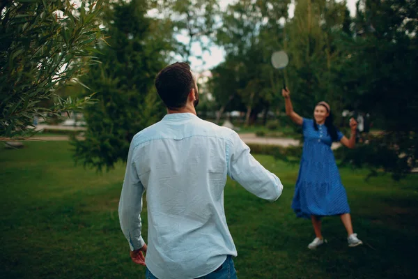 Junges erwachsenes Paar spielt Badminton im Park — Stockfoto