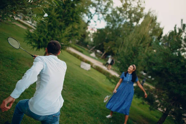 Молодая пара играет в бадминтон в парке — стоковое фото