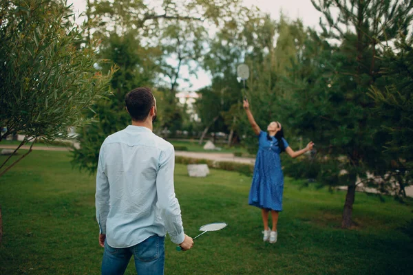 Young adult couple playing badminton in the park — Stock Photo, Image