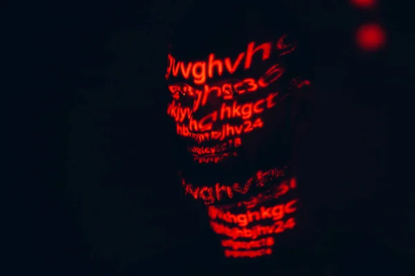 Ung man med röda bokstäver i ansiktet i mörkret. — Stockfoto