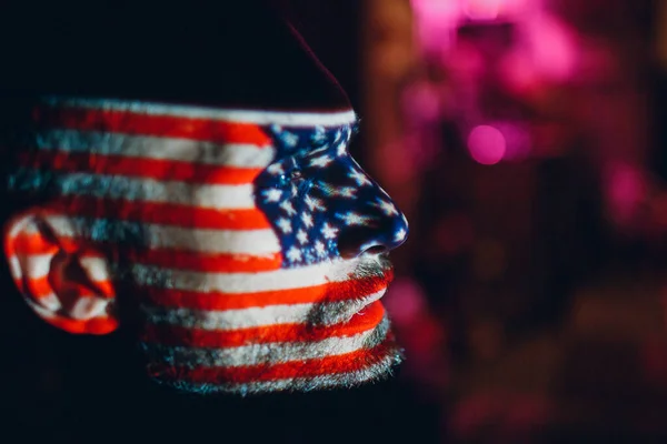 Hombre adulto con bandera de EE.UU. en la cara en la oscuridad. — Foto de Stock