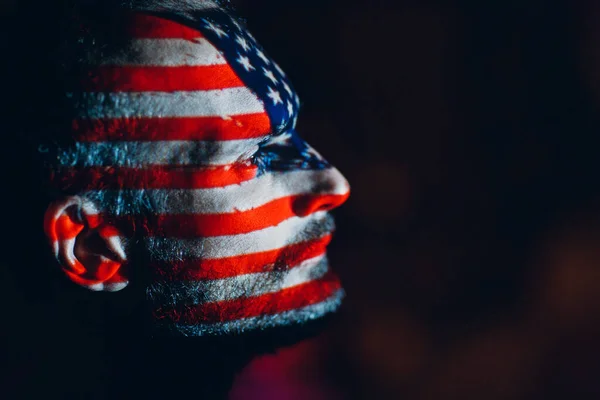 Hombre adulto con bandera de EE.UU. en la cara en la oscuridad. — Foto de Stock