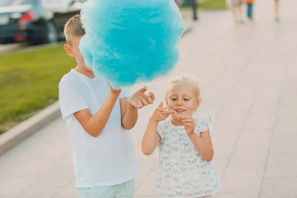 Šťastné děti chlapec a dívka jíst modré cukrové vaty venku — Stock fotografie