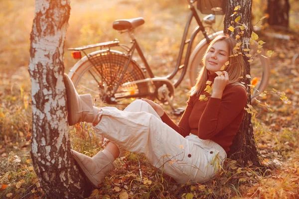 Happy active młoda kobieta siedzi z vintage rower w jesiennym parku o zachodzie słońca — Zdjęcie stockowe