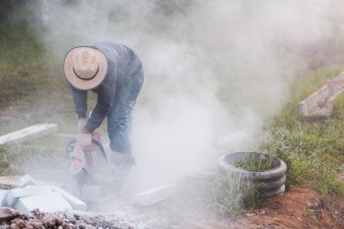 İşçi ustası kaldırımı dairesel testereyle keserken kaldırımı onarıyor.