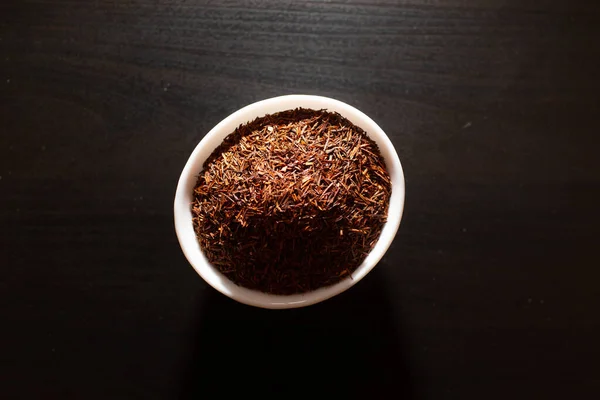 Rooibos tea fehér tányéron egy fa asztalon — Stock Fotó