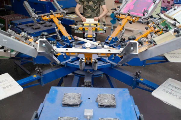 Serigrafia serigrafia processo di stampa serigrafica a fabbrica di vestiti. Carosello Telaio, tergipavimento e vernici plastisol — Foto Stock