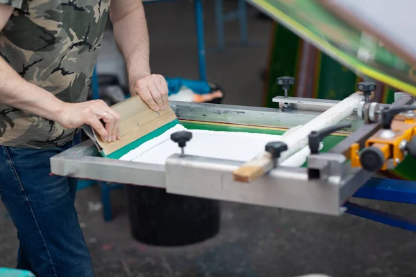 Serigrafia proces drukowania sitodruku w fabryce odzieży. Farby barwnikowe ramowe, squeegee i plastisol — Zdjęcie stockowe