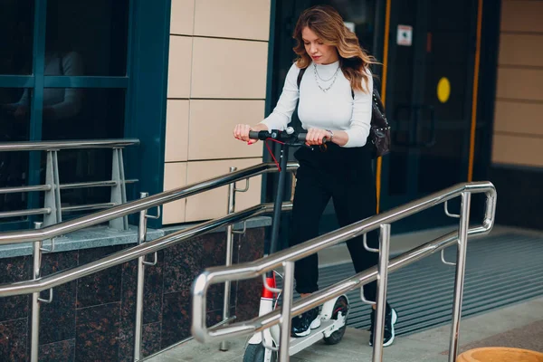 Jeune femme avec scooter électrique sur la rampe à la ville — Photo
