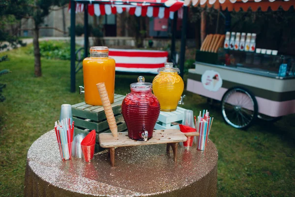 Meyve suyu büyük şişelerle dışarıda masanın üstünde.