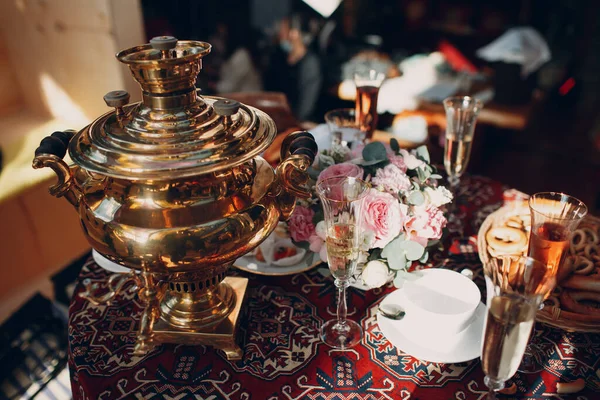 Mesa tradicional russa para beber chá com um samovar, copos de vinho, flores, doces, bagels e pães — Fotografia de Stock