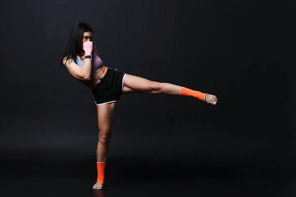 Sportsman muay thajská žena boxer pózování v tréninkovém studiu na černém pozadí. — Stock fotografie