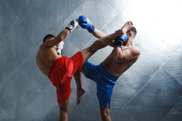 Δύο άνδρες πυγμάχοι αγωνίζονται muay thai kickboxing hgh κλωτσιά φόντο χάλυβα — Φωτογραφία Αρχείου