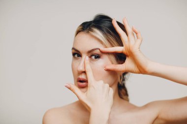 Genç bir kadın yüz jimnastiği yapıyor ve cilt ve kas gerdirme egzersizleri yapıyor.