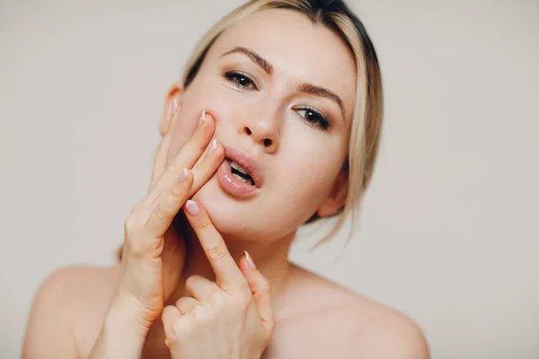 얼굴 체조를 하고 있는 젊은 성인 여성은 자신을 마사지하고 피부와 근육을 들어올리기 위해 얼굴 운동을 하고 있다 — 스톡 사진