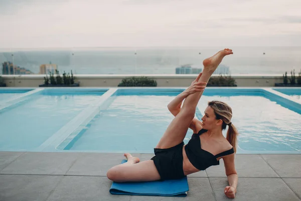 Biała kobieta ćwiczy jogę na basenie — Zdjęcie stockowe