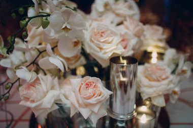 Beyaz çiçekler ve mumlarla süslenmiş düğün masası