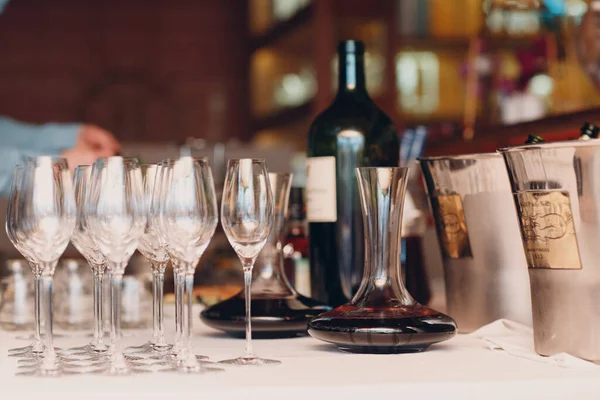 O garçom derrama vinho tinto de elite no decantador na mesa do restaurante — Fotografia de Stock