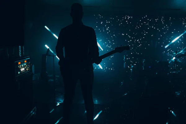 ギターナイトライフコンサートロック付きの劇的な照明の暗いステージ上のギタリストのシルエット — ストック写真