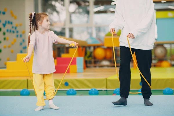 Crianças fazendo exercícios com pular corda no ginásio no jardim de infância ou escola primária. Crianças esporte e fitness conceito. — Fotografia de Stock