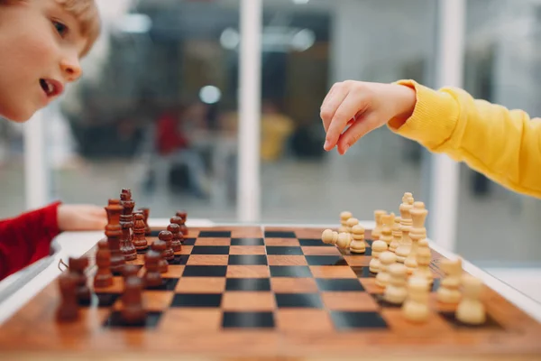 Niños pequeños jugando al ajedrez en el jardín de infantes o la escuela primaria. Juego de ajedrez para niños. — Foto de Stock