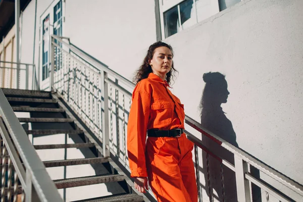 Joven morena rizada mujer en traje naranja. Mujer en mono colorido retrato. — Foto de Stock