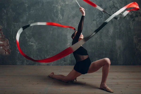 Jong meisje professionele gymnaste vrouw ritmische gymnastiek met lint in studio — Stockfoto