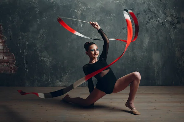 Jong meisje professionele gymnaste vrouw ritmische gymnastiek met lint in studio — Stockfoto