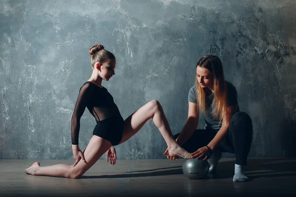 Jong meisje professionele turner met coach vrouw dans ritmische gymnastiek in studio — Stockfoto
