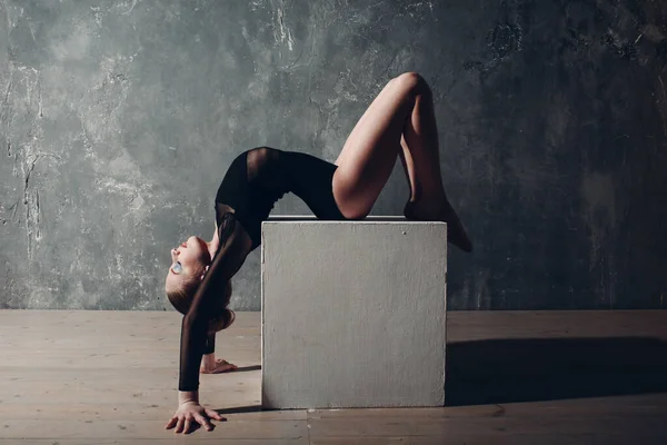 Jong meisje professionele turnster vrouw dans ritmische gymnastiek met wit kubus in studio — Stockfoto