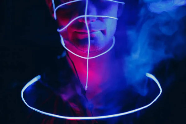 Retrato del hombre con líneas brillantes de neón en su cara. Concepto cyberpunk y realidad virtual. — Foto de Stock
