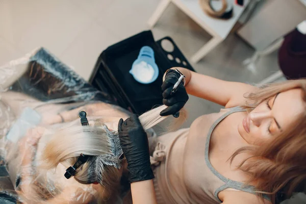 Jonge vrouw kapster stervende haar in schoonheidssalon. Professionele haarwortels kleuren — Stockfoto
