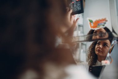 Taze kavrulmuş kahve çekirdekleri vakumlu poşetteki genç işçi kadın paketleme makinesi