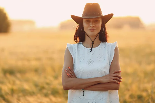 Donna contadino in cappello da cowboy a campo agricolo al tramonto con bagliore di sole — Foto Stock