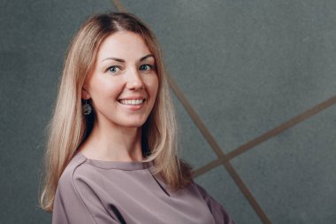 Genç, beyaz, Avrupalı, sarışın, gülümseyen bir kadın..