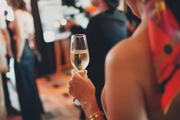 Mulher vista traseira segurando névoa copo resfriado de champanhe na mão na festa — Fotografia de Stock