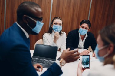 Maske takan farklı meslekdaşlar toplantısı. İş adamları erkek ve kadın grup konferansı.