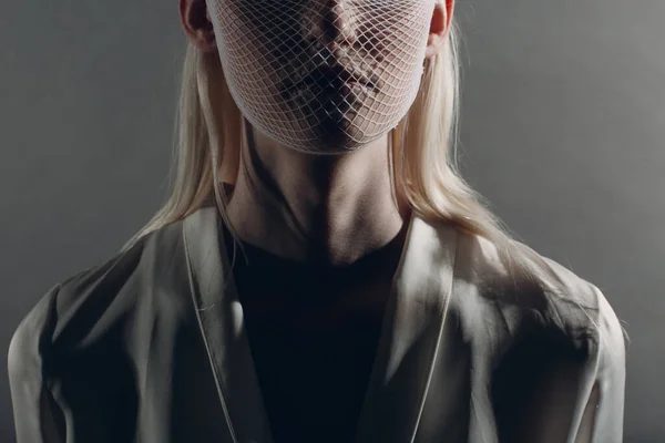 Retrato de primer plano de una mujer rubia albina blanca caucásica modelo de moda con máscara médica de cuarentena malla gruesa sobre fondo gris. Concepto de protección del coronavirus Covid-19 — Foto de Stock