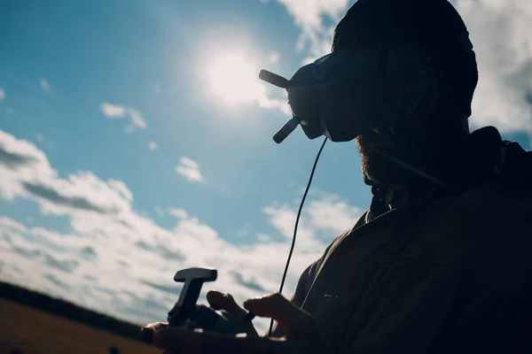 Man controlling fpv quadcopter drone with goggles antenna remote controller — Stock Photo, Image