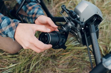 New York, ABD - 18 Eylül 2021: DJI Inspire 2 kuadcopter drone 'u kontrol eden ve havadan uçmadan önce kamera lensi takan ve çekim yapan adam pilot.